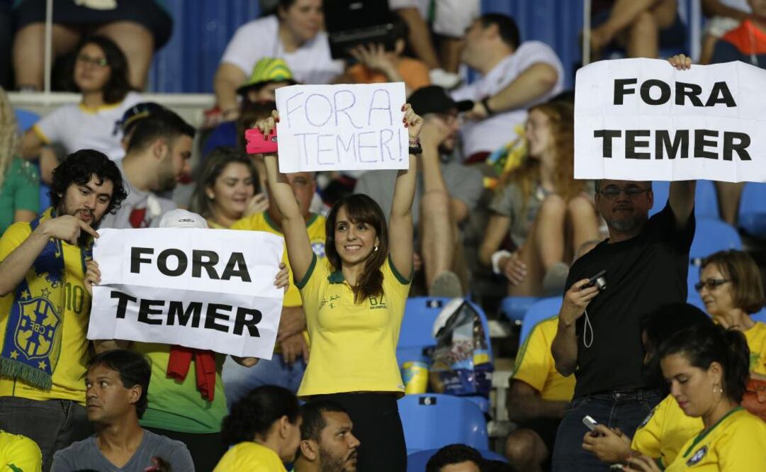 Fanáticos muestran carteles con la frase "Fuera Temer" antes de un partido entre Brasil y Suecia en el fútbol de los Juegos Olímpicos en Río de Janeiro (Foto: AP)