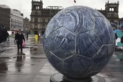 Bajo la lluvia, capitalinos acuden a transmisión del Mundial en el Zócalo