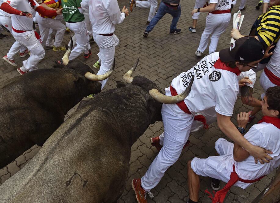 Dos toros de la ganadería de José Escolar Gil a su llegada a la curva de Telefónica durante el tercer encierro de los sanfermines 2016 ( EFE/Daniel Fernández)