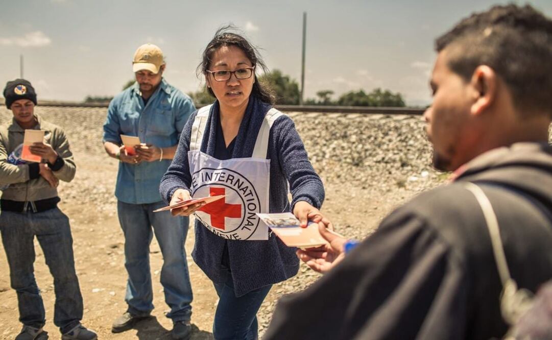 Una cruzrojista mexicana entrega a un migrante en Ciudad Serán, en Puebla, México, un folleto con información sobre el fenómeno migratorio que ofrece la Cruz Roja Internacional. (CICR/Jesús Cornejo)