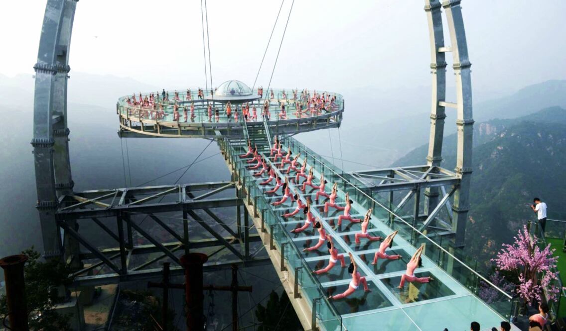Practicantes de yoga en el mayor mirador del mundo de cristal y titanio con forma de platillo en Beijing: el Jingdong Stone Forest Gorge. (Foto: EFE/Lao Cai)