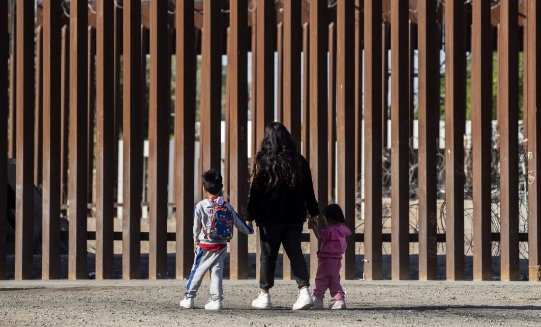 Una familia de migrantes, que incluye a dos niños, espera en la frontera de EU con México, en una fotografía de archivo. Foto: EFE