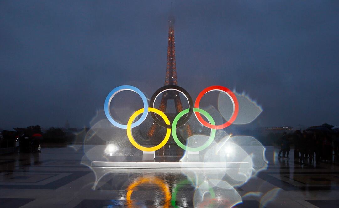 Esta foto que fue tomada con una lente con gotas de lluvia muestra los anillos olímpicos en la plaza Trocadero que observa la Torre Eiffel. Foto: AP Foto/Francois Mori