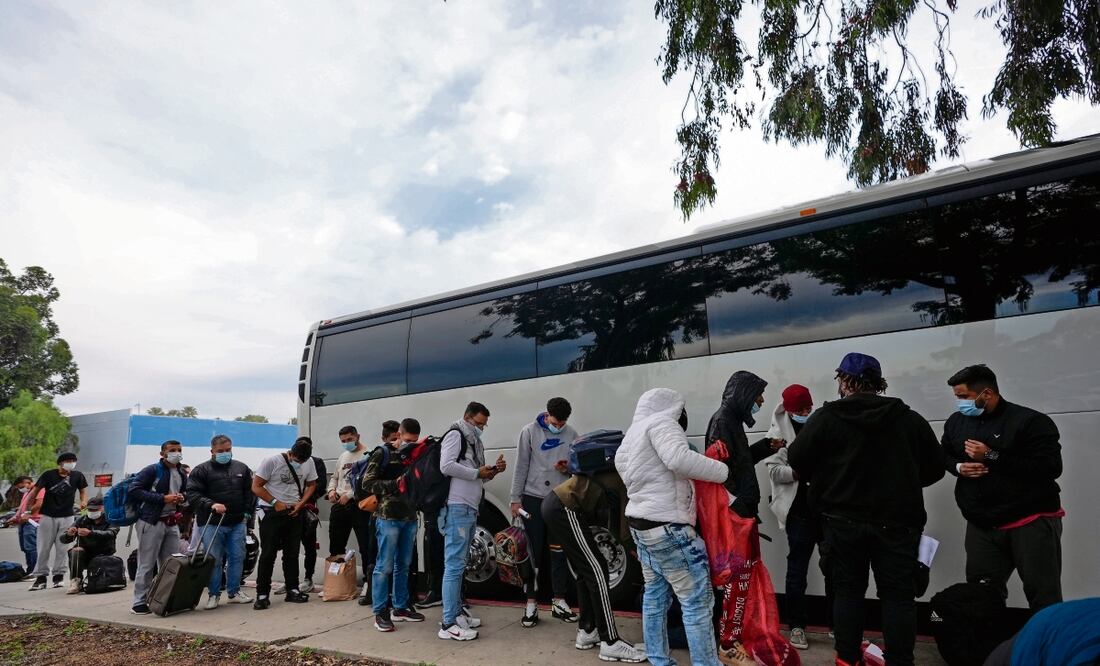 Migrantes descargan sus pertenencias de un autobús en San Diego, California. Foto: Gregory Bull / AP