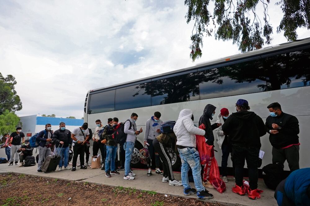 Migrantes descargan sus pertenencias de un autobús en San Diego, California. Foto: Gregory Bull / AP