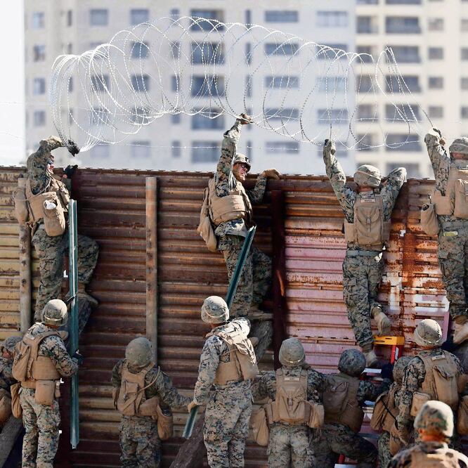 Marines de EU colocan alambrada de púas sobre la valla fronteriza en el punto de entrada de Tijuana, en San Ysidro, del lado de San Diego. MIKE BLAKE. REUTERS