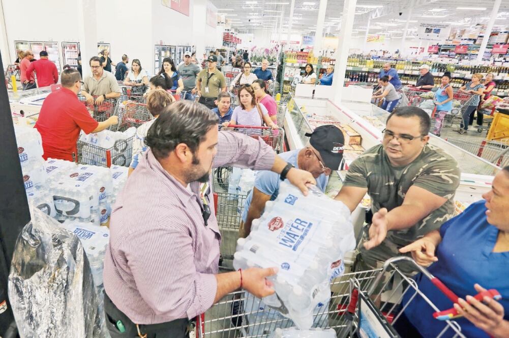 Residentes compran agua y otros insumos, adelantándose a la llegada de Irma, en Miami. El huracán alcanzó la categoría cinco. (ROBERTO KOLTUN. AP)