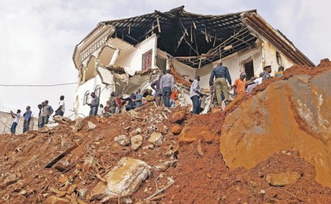 Locals reunited in front of a building damaged by a mudslide in Freetown. President declares seven days of mourning - Photo: Liu Yu/XINHUA