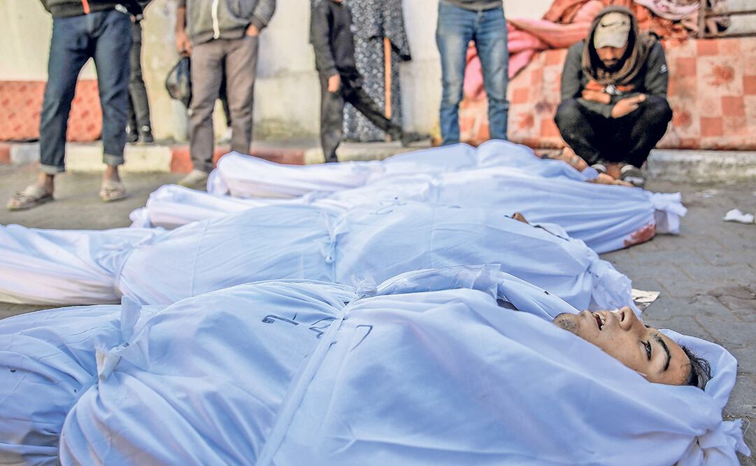 Familiares de palestinos que murieron durante la entrega de ayuda humanitaria en Gaza esperan afuera del hospital Al-Shifa. Foto: AFP