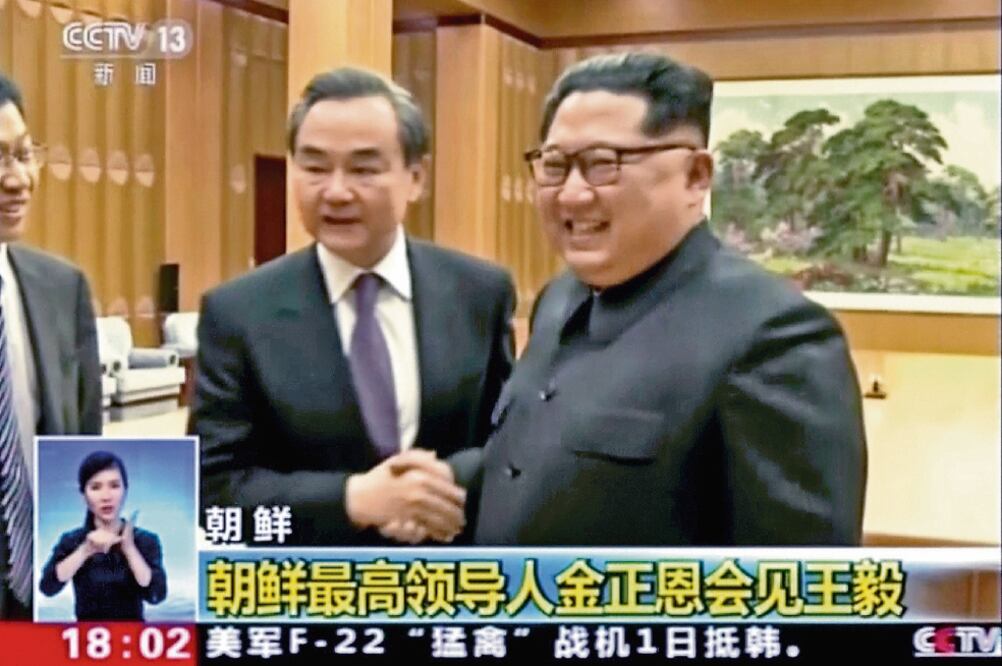 El ministro chino de Exteriores, Wang Yi (izq.), con el presidente norcorean o, Kim Jong-un, durante la reunión que sostuvieron ayer en Pyongyang (AP)