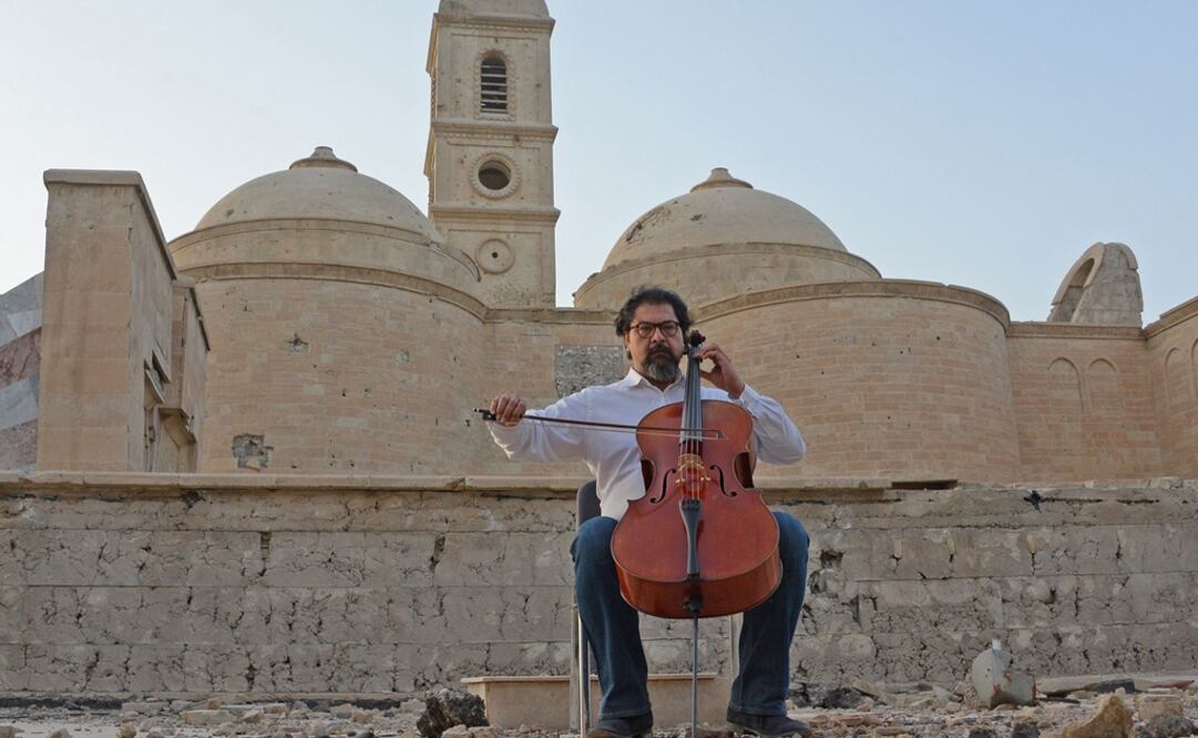 El violonchelista y director de orquesta iraquí-estadounidense Karim Wasfi toca entre las ruinas de Mosul un mensaje de "paz y coexistencia". Foto: AFP /Zaid Al-Obeidi 