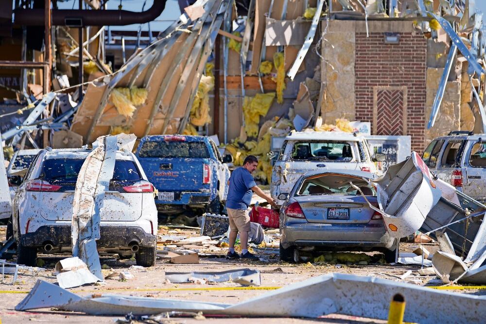 Un hombre mira un auto dañado después de que un tornado pasara el domingo en Valley View, Texas. Foto: Julio Cortez AP