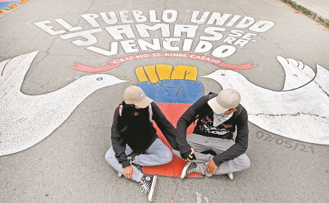 Una pareja de manifestantes se toma las manos al posar para una foto durante las protestas en la carretera Panamericana en Cali. Foto: Luis Robayo. AFP