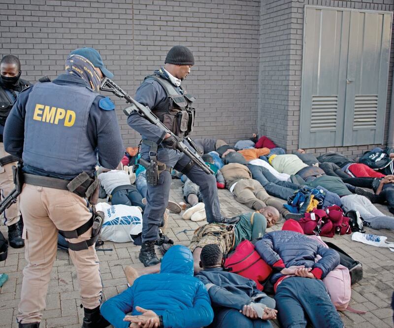 Fuerzas de seguridad vigilan a los saqueadores arrestados en Johannesburgo, Sudáfrica. Foto: KIM LUDBROOK. EFE