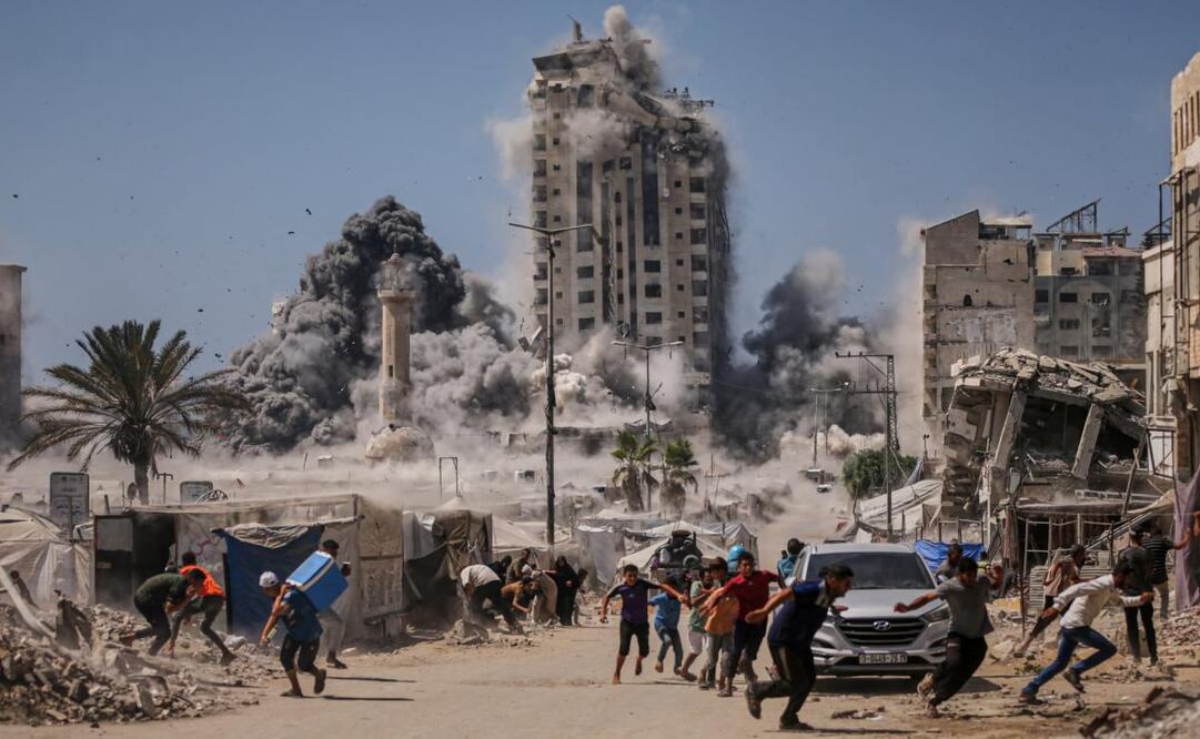 Los palestinos corren a cubrirse durante un ataque israelí contra un edificio alto en Ciudad de Gaza, el viernes 5 de septiembre de 2025, después de que el Ejército israelí emitiera una advertencia. Foto: AP
