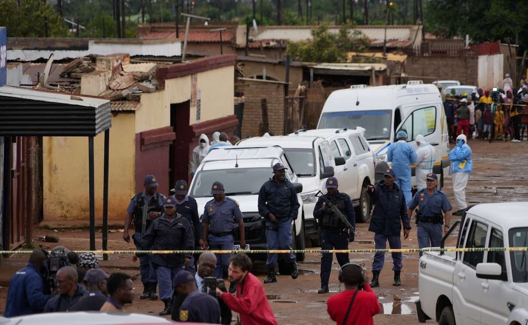 Policías sudafricanos se reúnen en el lugar de un tiroteo masivo donde hombres armados mataron a nueve personas e hirieron al menos a 10 en un pub en Bekkersdal, Sudáfrica el domingo 21 de diciembre de 2025. Foto: AP