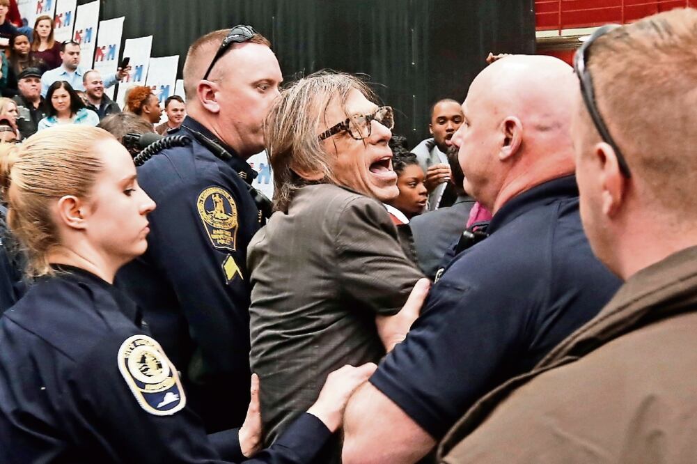 Chris Morris, fotoperiodista de la revista 'Time', fue agredido también en la protesta que surgió en medio del mitin de Trump ayer, en Virginia (STEVE HELBER. AP)