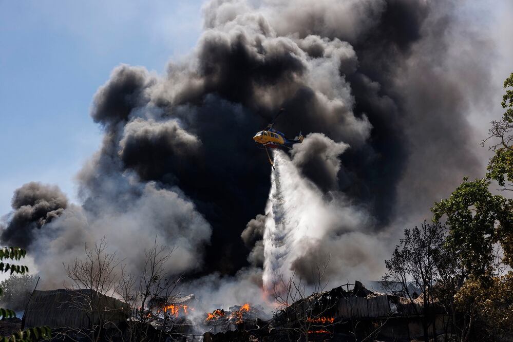 Un helicóptero lanza agua sobre un incendio en la municipalidad de  Oreokastro cerca de Tesalónica, en Grecia.  FOTO: EFE