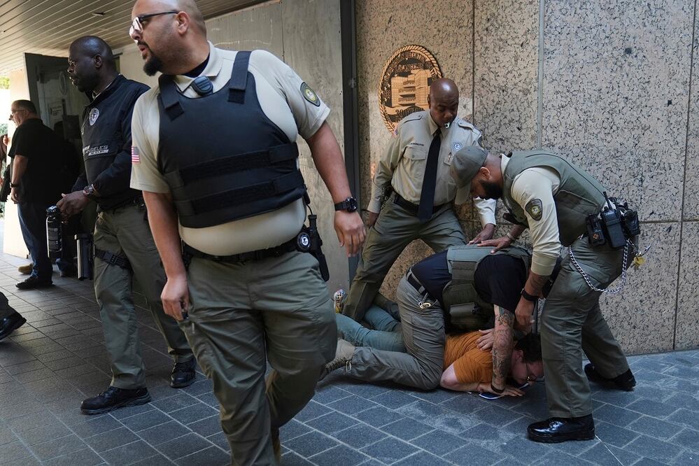 Autoridades detienen a un manifestante, durante una protesta contra las redadas realizadas este viernes 6 de junio en Los Ángeles. FOTO: JAE C. HONG. AP