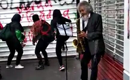 No dejó de tocar el saxofón aun entre pintas y golpes de la marcha del 8M