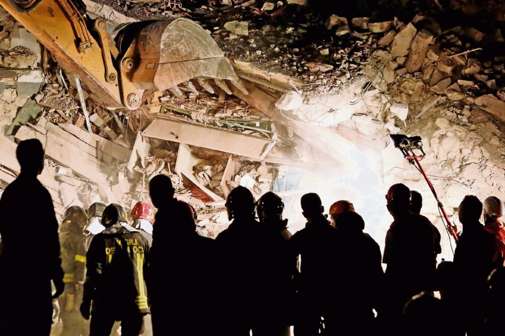 Rescatistas buscaban anoche en Pescara del Tronto sobrevivientes de una casa colapsada tras el terremoto que sacudió el centro de Italia (REMO CASILLI. REUTERS)