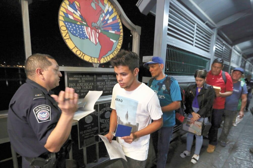 Cubanos muestran sus identificaciones a funcionarios aduanales en Laredo, Texas, donde tenían citas sobre sus solicitudes de asilo. Foto: FERNANDO LLANO. AP