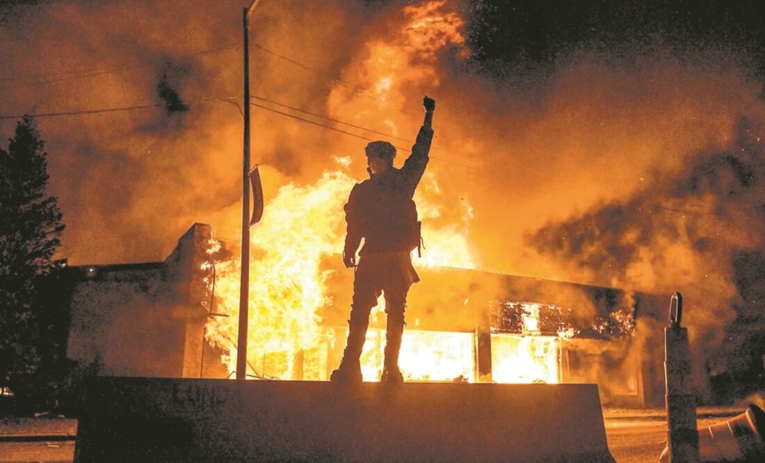 A protester reacts standing in front of a burning building set on fire during a demonstration in Minneapolis, Minnesota, over the death of George Floyd, a black man who died after a white policeman kneeled on his neck - Photo: Chandan Khanna/AFP