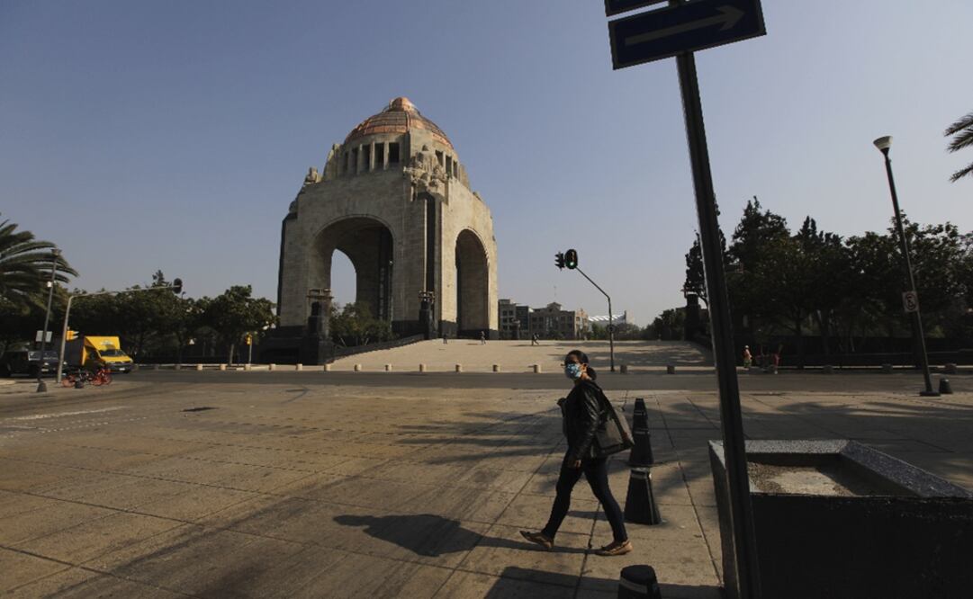 A woman wearing a face mask to prevent the spread of the new coronavirus walks through an empty plaza at the Revolution Monument in Mexico City - Photo: Fernando Llano/AP