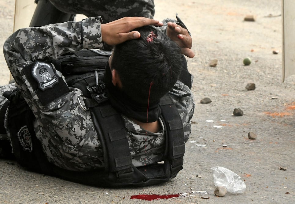 Un policía herido permanece en el suelo tras los enfrentamientos durante un operativo para despejar un bloqueo carretero en Bolivia (06/06/2026). Foto: AFP