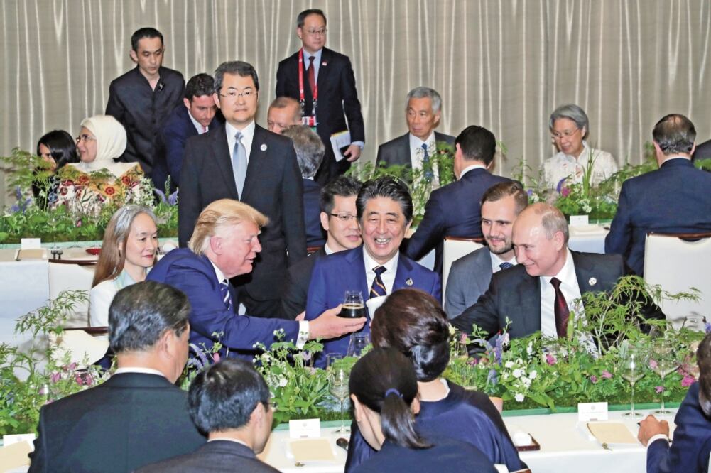 El presidente estadounidense, Donald Trump, brinda con el mandatario ruso, Vladimir Putin. Al centro los ve el primer ministro de Japón, Shinzo Abe, durante la cumbre del G20, en Osaka, Japón. Foto: REUTERS