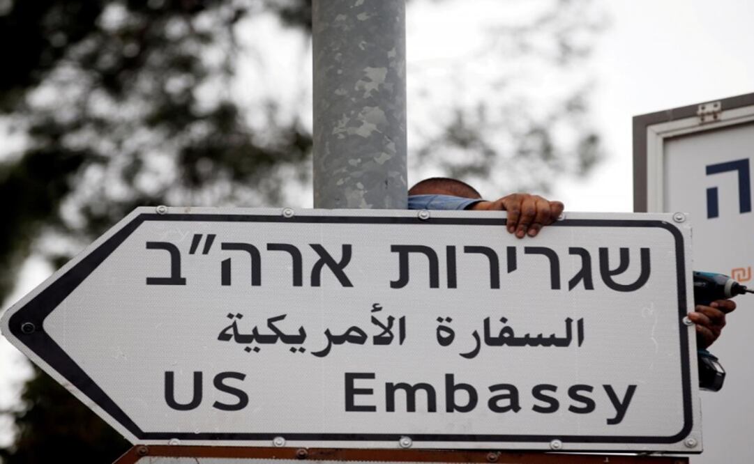 A worker hangs a road sign directing to the U.S. embassy, in the area of the U.S. consulate in Jerusalem - Photo: Ronen Zvulun/REUTERS