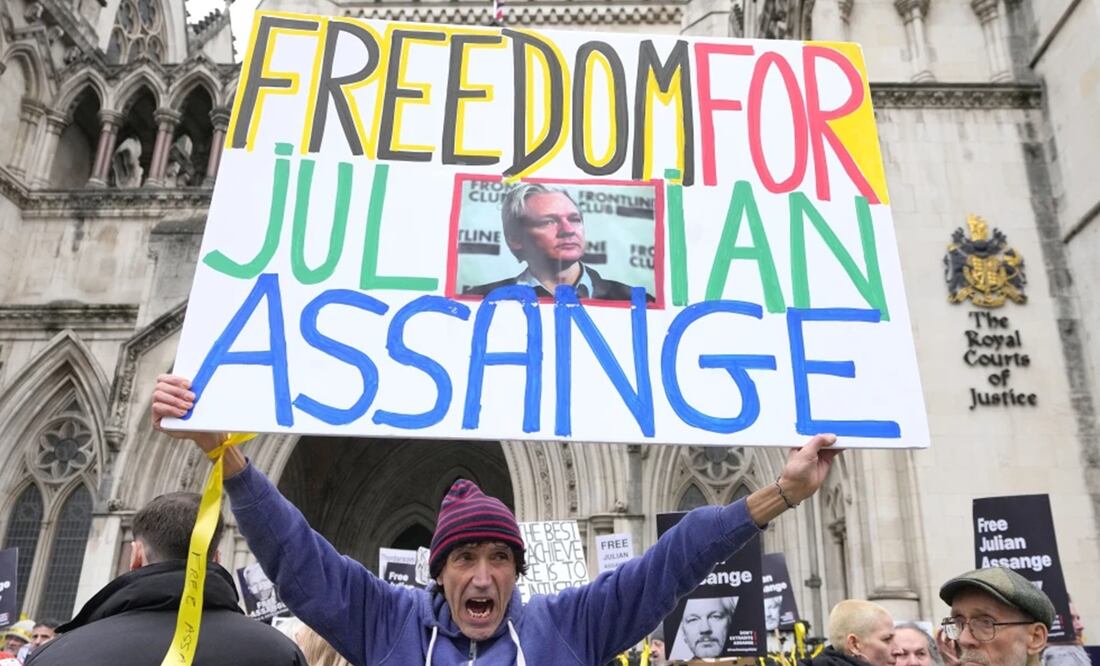 Manifestantes alzan carteles con la leyenda “libertad a Julian Assange” frente a los tribunales de Londres. Foto: AP