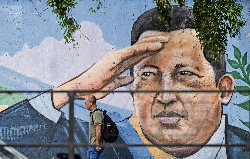 Un venezolano pasa junto a un mural del fallecido expresidente Hugo Chávez, en una avenida de Caracas.  Foto: Yuri Cortez | AFP