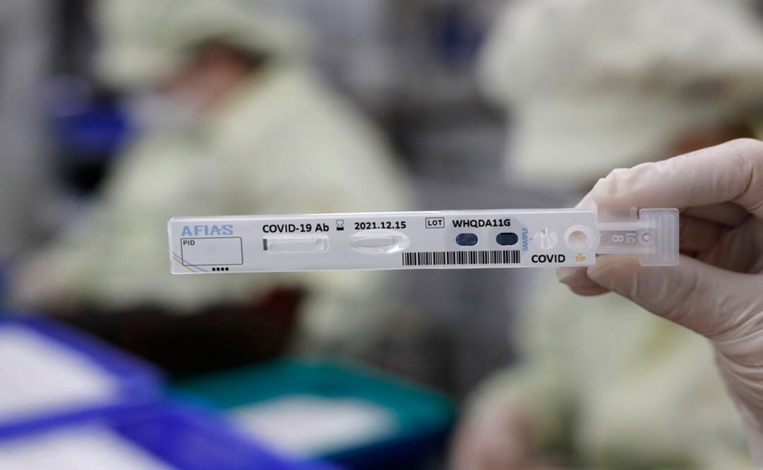 An employee holds up an antibody test cartridge of AFIAS COVID-19 Ab testing kit used in diagnosing the coronavirus - Photo: Lee Jin-man/AP