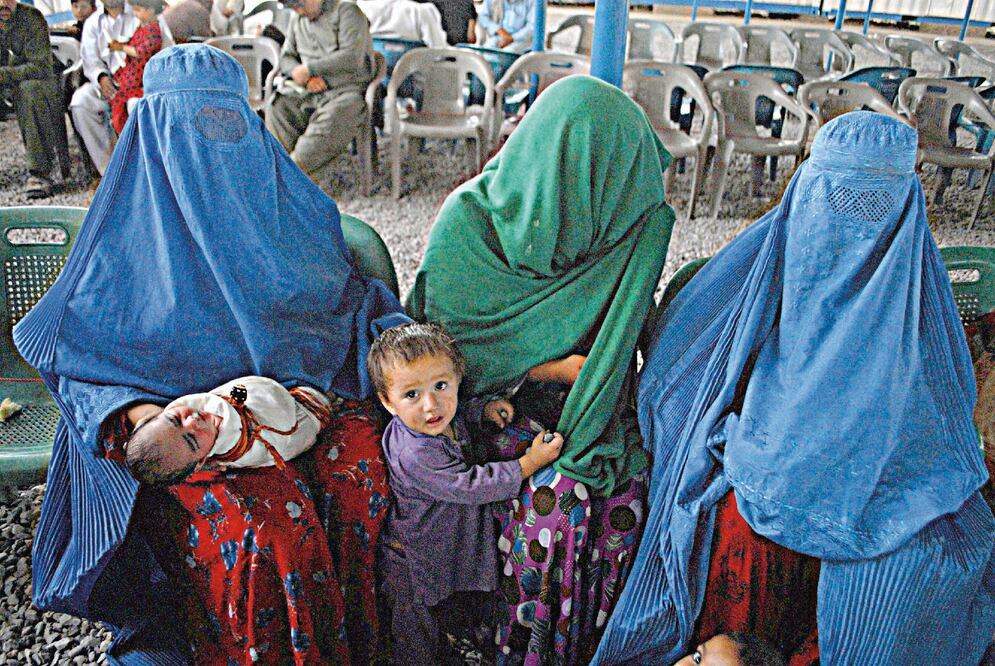 Refugiados afganos aguardaban el sábado en la oficina del centro de registo del ACNUR antes de regresar a Afganistan, en el Día Internacional del Refugiado, en Peshawar, Pakistán. XINHUA