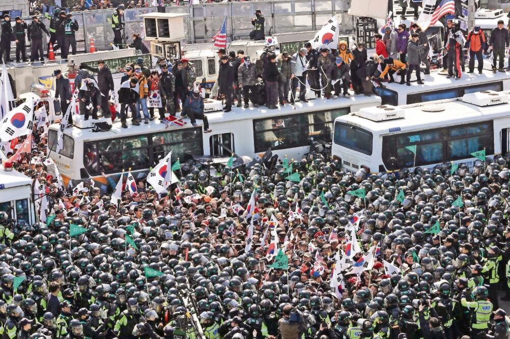 Manifestantes que apoyan a la ex presidenta de Corea del Sur Park Geun-hye se enfrentaron ayer a elementos de policía cerca de la Corte Constitucional en Seúl (REUTERS)