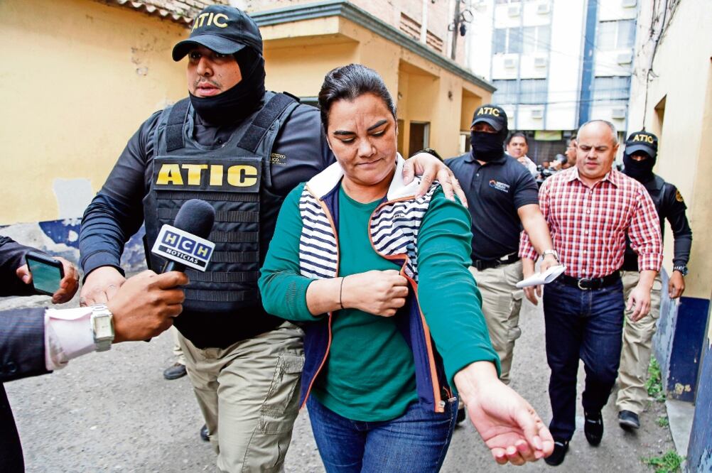 Policías escoltan a la ex primera dama Rosa Elena Bonilla, en Tegucigalpa. Un juez le dictó “detención judicial” y le fijó audiencia preliminar para el 2 de marzo por malversación de caudales públicos, lavado de activos y asociación ilícita. (FERNANDO AN)