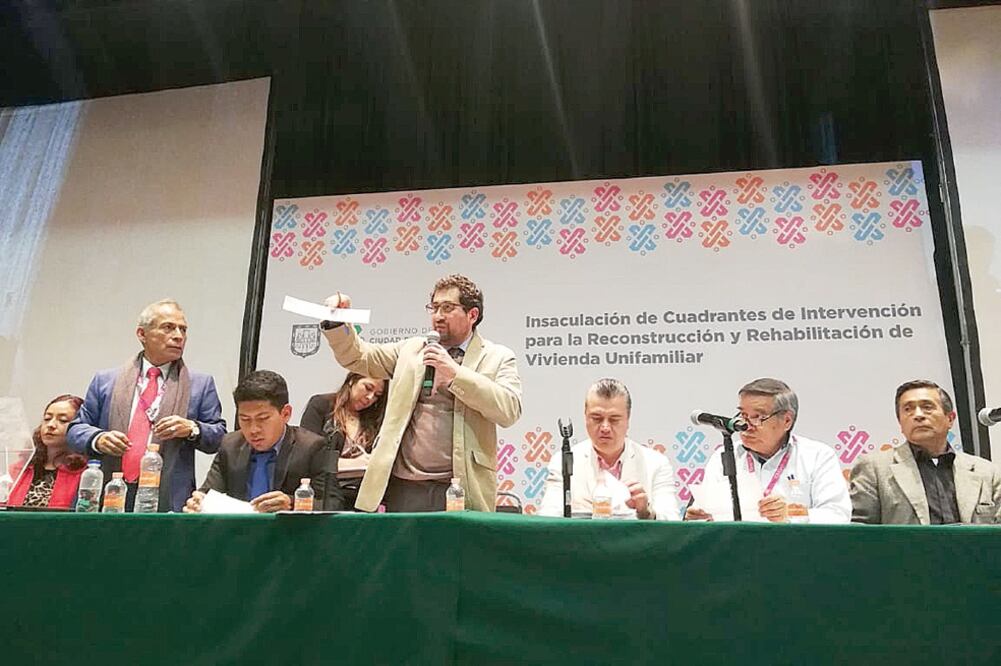 César Cravioto, titular de la Comisión para la Reconstrucción (centro), durante el sorteo que duró más de cuatro horas, y que consistió en meter en una tómbola los nombres de las firmas interesadas en edificar viviendas. Foto: ESPECIAL
