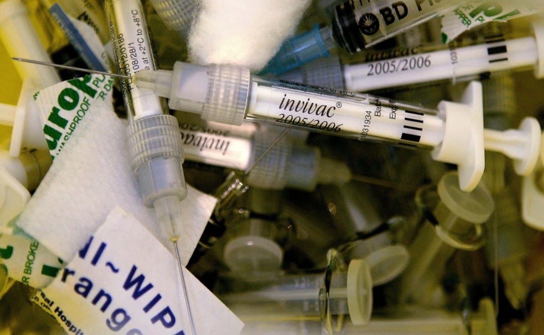 Used flu vaccine syringes lie in a bin at a clinic – Photo: Dylan Martínez/REUTERS	