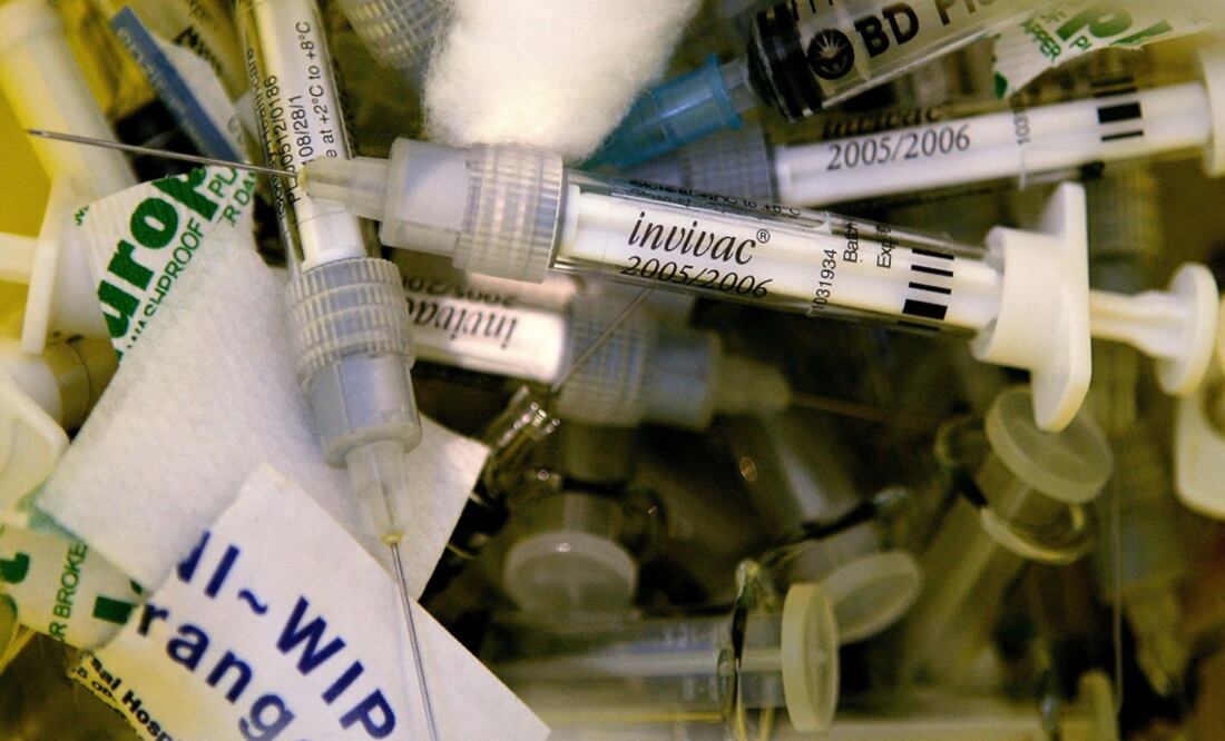 Used flu vaccine syringes lie in a bin at a clinic – Photo: Dylan Martínez/REUTERS