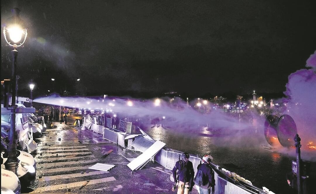 Un cañón de agua de la policía rocía un tambor de carrete de cable de madera en llamas durante una manifestación en la Plaza de la Concordia. Foto: Geoffroy Van der Hasselt / AFP