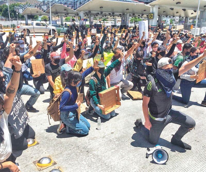En la garita El Chaparral, en Tijuana, Baja California, jóvenes se arrodillaron, alzaron el puño como símbolo de paz y en reclamo al abuso policial. Foto: GABRIELA MARTÍNEZ. EL UNIVERSAL