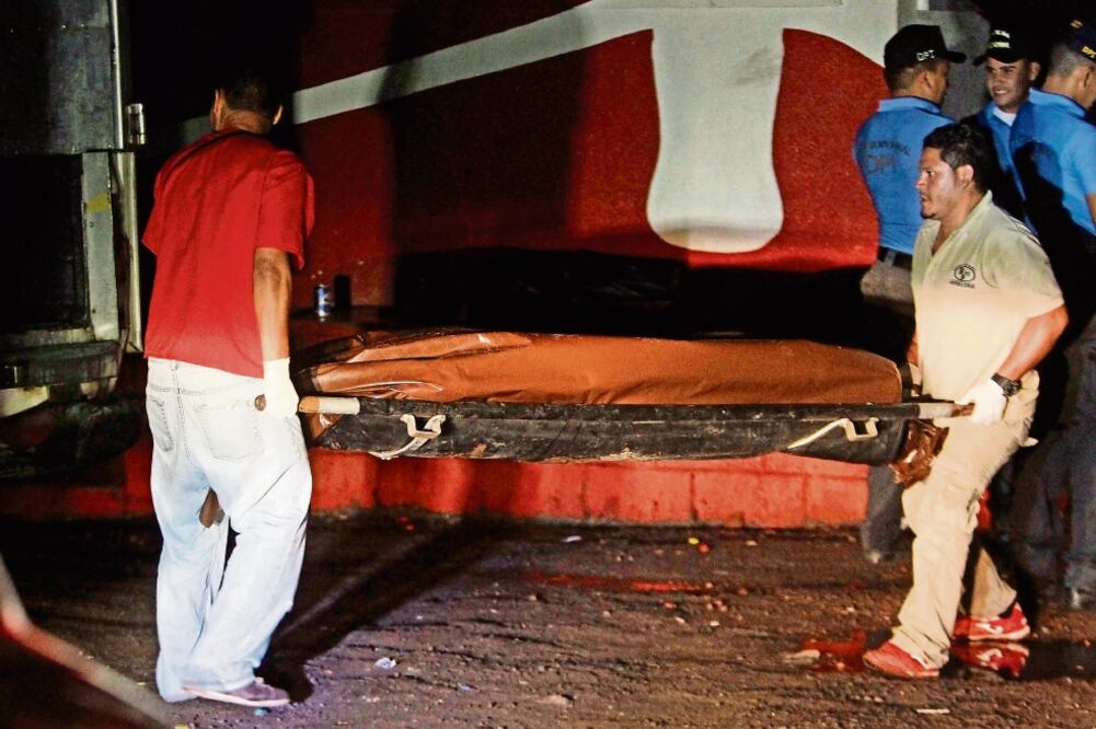 Forenses, en una zona afuera de Tegucigalpa. Ayer un grupo armado asesinó a jóvenes que estaban cerca de un bar en la colonia Altos de Loarque (FERNANDO ANTONIO. AP)