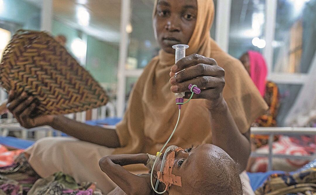Amina Muhamat Moussa ayudó a sostener al bebé de una madre que descansa en el área de recuperación de pacientes desnutridos en el hospital Tchad. Foto: Caballero-Reynolds/ AFP.