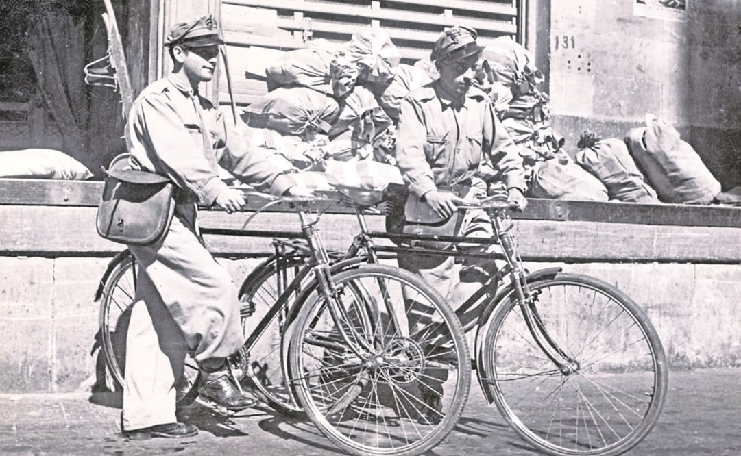 Dos carteros con sus respectivas bicicletas, a finales de los 50, poco antes de salir a las calles de esta gran ciudad a repartir correspondencia.