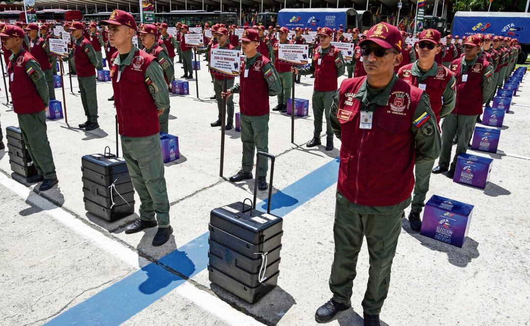 Miembros de la Guardia Nacional, junto a máquinas de votación y urnas, en Caracas Foto: AP