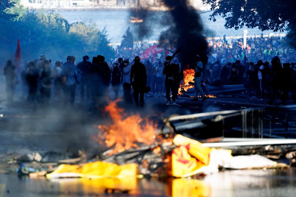 Manifestantes contra el G7 se enfrentaron con la policía en Ginebra, previo a la cumbre que empieza este lunes. FOTO: EFE