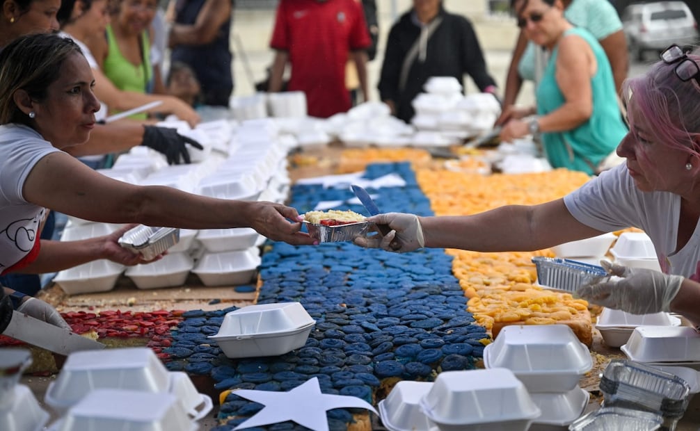 Voluntarios trasladan y reparten las porciones del pastel en centros de atención para familias desplazadas por los terremotos del 24 de junio (18/07/2026). Foto: AFP