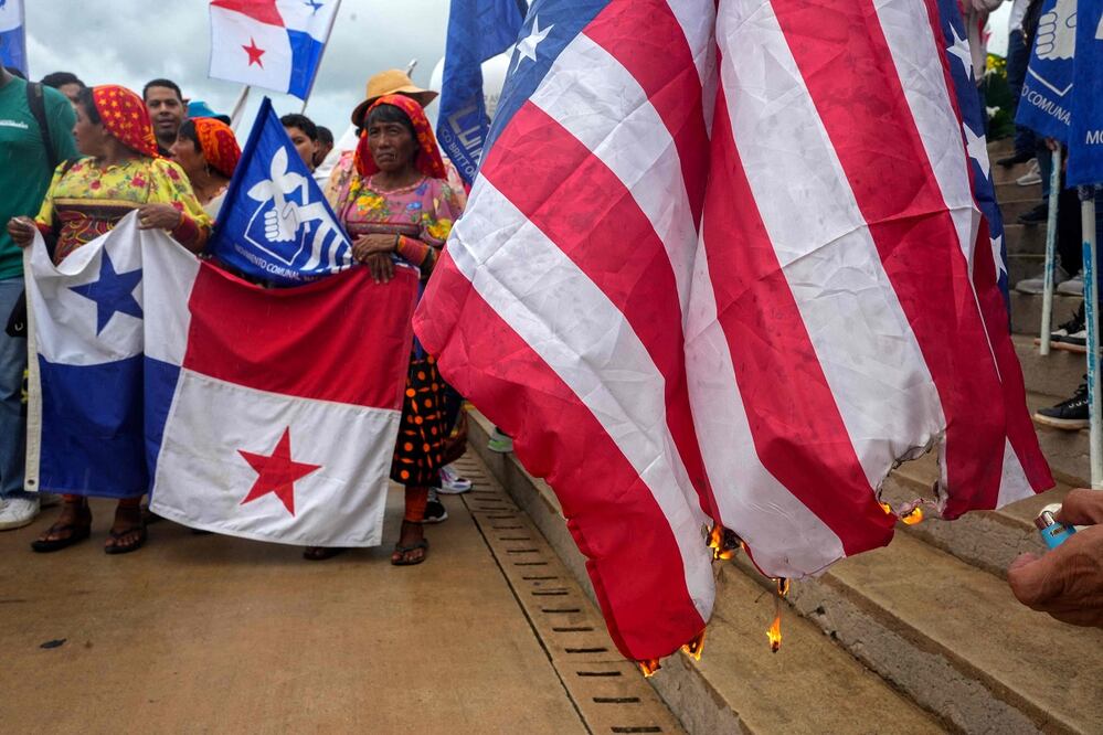 Manifestantes queman una bandera estadounidense durante una protesta contra el presidente electo de Estados Unidos, Donald Trump, celebrada frente al edificio de la Administración del Canal de Panamá en Ciudad de Panamá el 31 de diciembre de 2024. FOTO: ARNULFO FRANCO. AFP/ Archivo