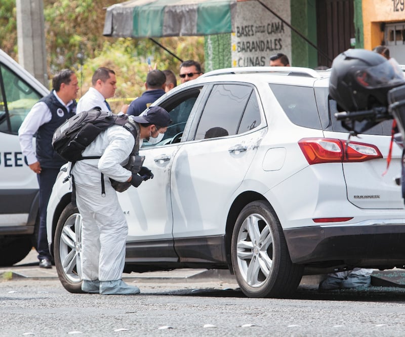 Peritos de la fiscalía de Michoacán recogen evidencia del vehículo en el que viajaba el legislador local perredista Érick Juárez Blanquet, asesinado du ra nte un atentado en Morelia. El gobernador, así como los distintos grupos parlamentarios en el Congre